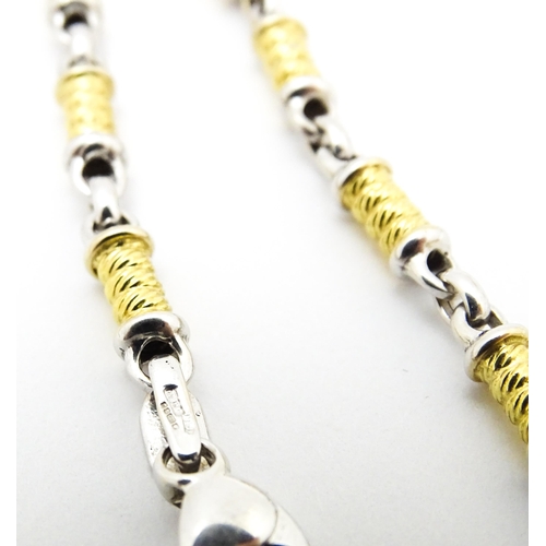 721 - An 18ct yellow and white gold necklace with cross formed pendant set with diamonds. Chain approx. 22... 