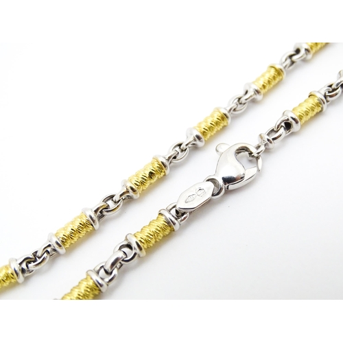 721 - An 18ct yellow and white gold necklace with cross formed pendant set with diamonds. Chain approx. 22... 