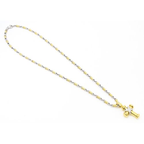 721 - An 18ct yellow and white gold necklace with cross formed pendant set with diamonds. Chain approx. 22... 