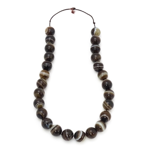 742 - A string of Scottish agate beads with banded decoration. The largest approx 5/8