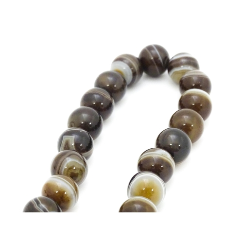 742 - A string of Scottish agate beads with banded decoration. The largest approx 5/8