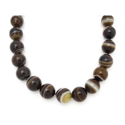 742 - A string of Scottish agate beads with banded decoration. The largest approx 5/8