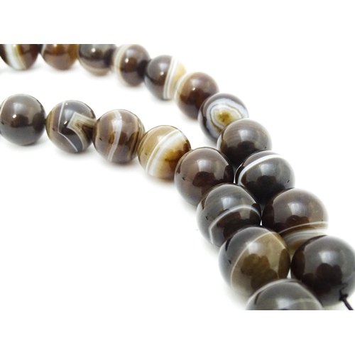 742 - A string of Scottish agate beads with banded decoration. The largest approx 5/8