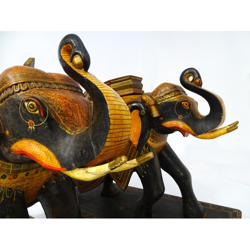 1304 - Two large Kashmir wooden models of elephants with polychrome decoration raised on rectangular bases.... 