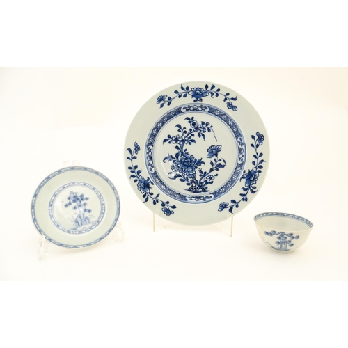 17 - A Chinese Nanking Cargo blue and white tea bowl and saucer decorated with pine trees and banded bord... 