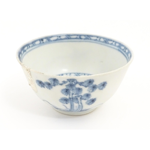 17 - A Chinese Nanking Cargo blue and white tea bowl and saucer decorated with pine trees and banded bord... 