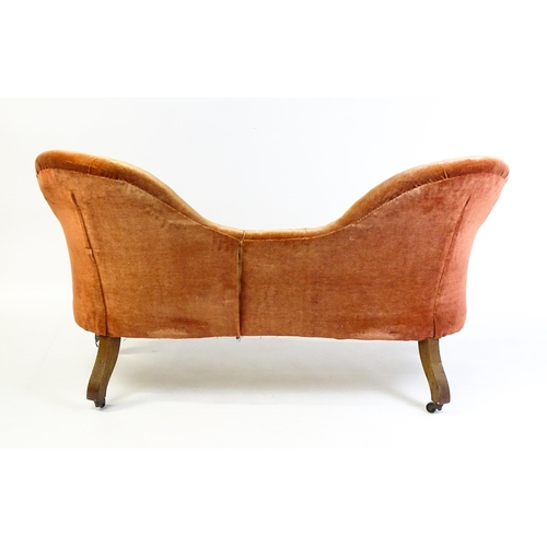 1447 - A late 19thC hump back / camel back sofa with deep buttoned upholstery and sprung seat, the sofa rai... 