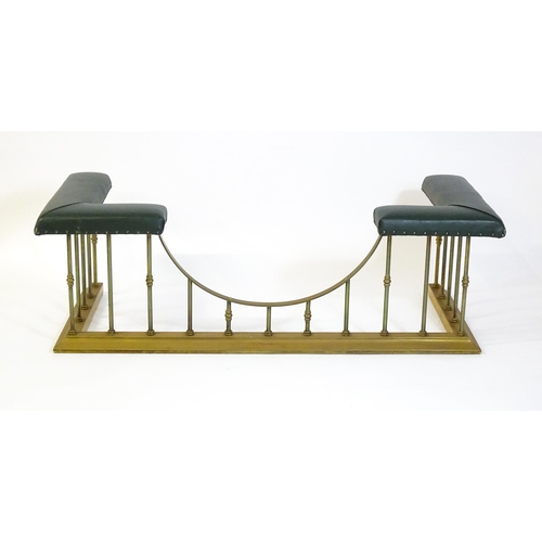 1460 - A late 20thC club fender, with two leather upholstered seats raised on brass railed supports and a s... 