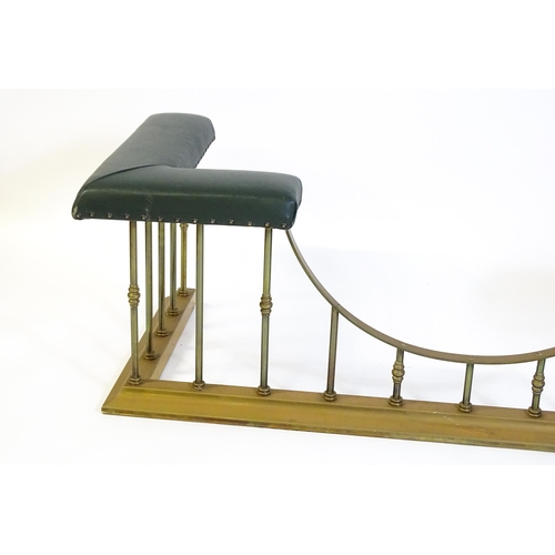 1460 - A late 20thC club fender, with two leather upholstered seats raised on brass railed supports and a s... 