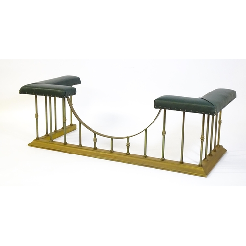 1460 - A late 20thC club fender, with two leather upholstered seats raised on brass railed supports and a s... 