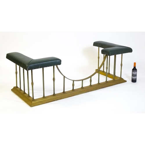 1460 - A late 20thC club fender, with two leather upholstered seats raised on brass railed supports and a s... 