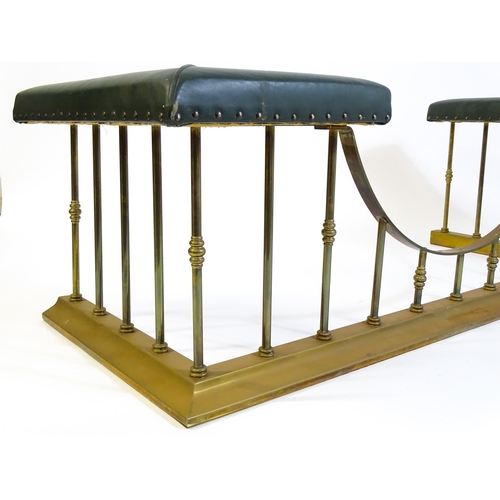 1460 - A late 20thC club fender, with two leather upholstered seats raised on brass railed supports and a s... 