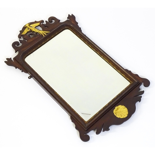 1533 - A late 19thC / early 20thC mahogany mirror, with a pierced frame and gilt painted shell and hoho bir... 