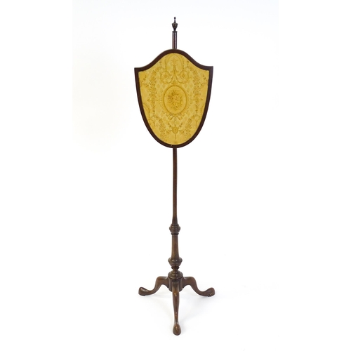 1618 - An early 20thC  pole screen with a shield shape embroidery raised on a turned pole and three cabriol... 