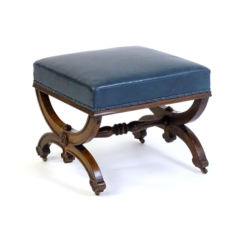 1436 - A Victorian 19thC mahogany Gothic stool, the leather upholstered seat raised on an x-frame base with... 