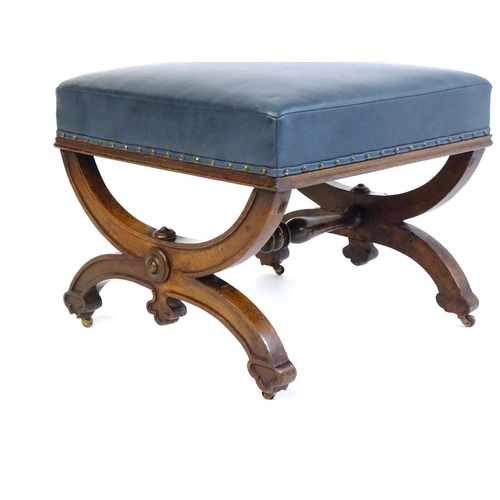 1436 - A Victorian 19thC mahogany Gothic stool, the leather upholstered seat raised on an x-frame base with... 