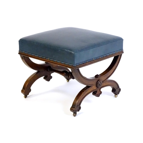 1436 - A Victorian 19thC mahogany Gothic stool, the leather upholstered seat raised on an x-frame base with... 