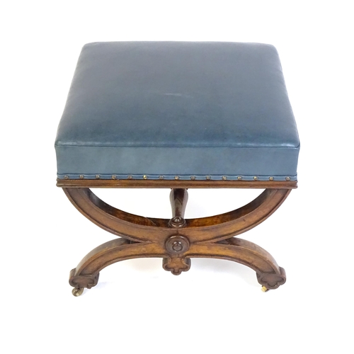 1436 - A Victorian 19thC mahogany Gothic stool, the leather upholstered seat raised on an x-frame base with... 