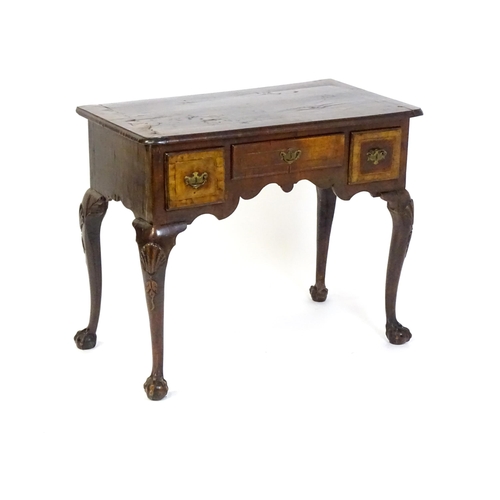 1443 - An 18thC walnut low boy with a moulded and cross banded top above three short drawers with a shaped ... 