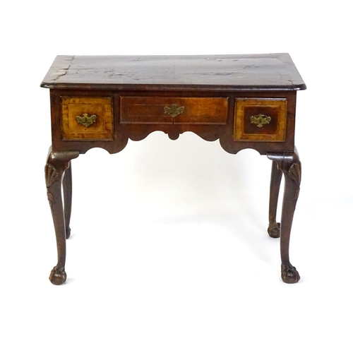 1443 - An 18thC walnut low boy with a moulded and cross banded top above three short drawers with a shaped ... 