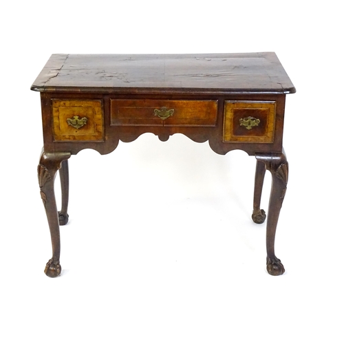 1443 - An 18thC walnut low boy with a moulded and cross banded top above three short drawers with a shaped ... 