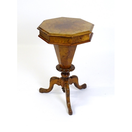 1468 - A Victorian walnut sewing table, with a moulded octagonal top, trumped shaped pedestal with carved d... 