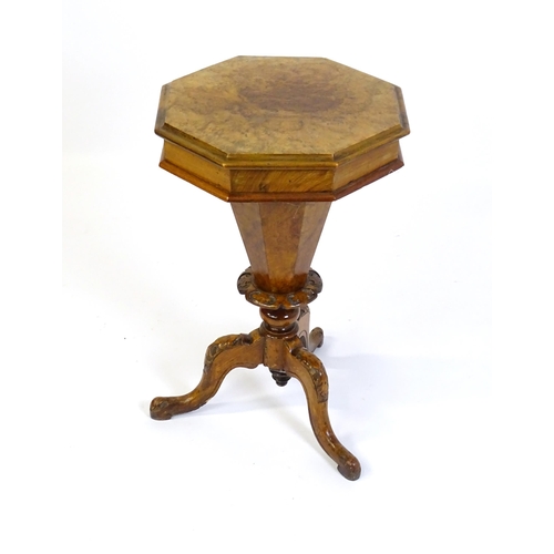 1468 - A Victorian walnut sewing table, with a moulded octagonal top, trumped shaped pedestal with carved d... 