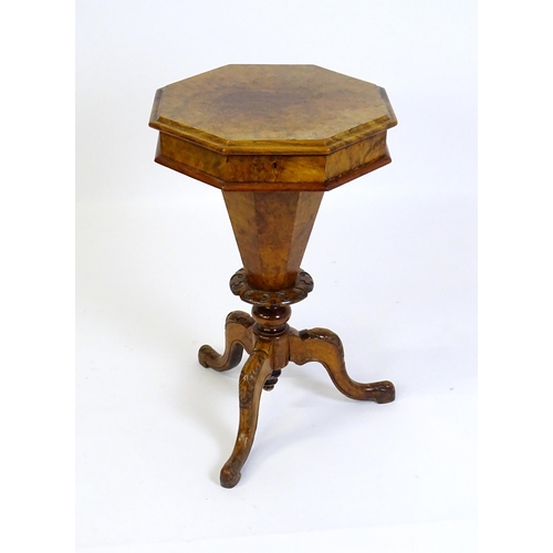 1468 - A Victorian walnut sewing table, with a moulded octagonal top, trumped shaped pedestal with carved d... 