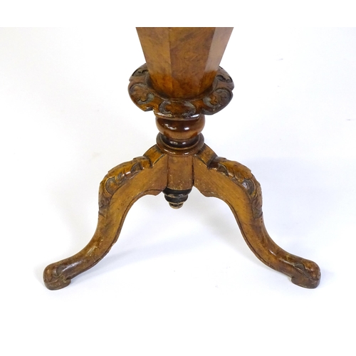 1468 - A Victorian walnut sewing table, with a moulded octagonal top, trumped shaped pedestal with carved d... 