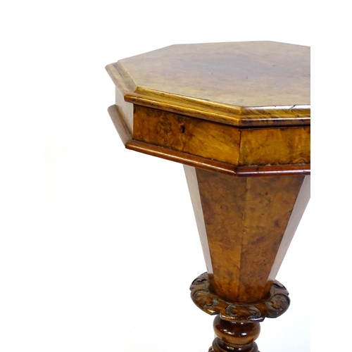 1468 - A Victorian walnut sewing table, with a moulded octagonal top, trumped shaped pedestal with carved d... 