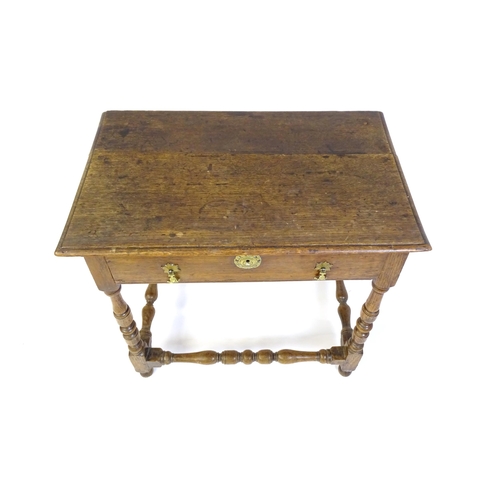 1469 - An 18thC oak side table with a moulded top above a single long frieze drawer, the table raised on tu... 