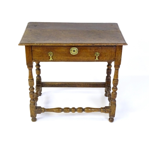 1469 - An 18thC oak side table with a moulded top above a single long frieze drawer, the table raised on tu... 