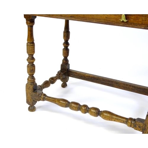 1469 - An 18thC oak side table with a moulded top above a single long frieze drawer, the table raised on tu... 