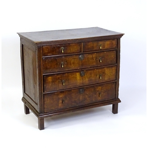 1479 - An early / mid 18thC oak and walnut chest of drawers, the moulded top above two short over three lon... 