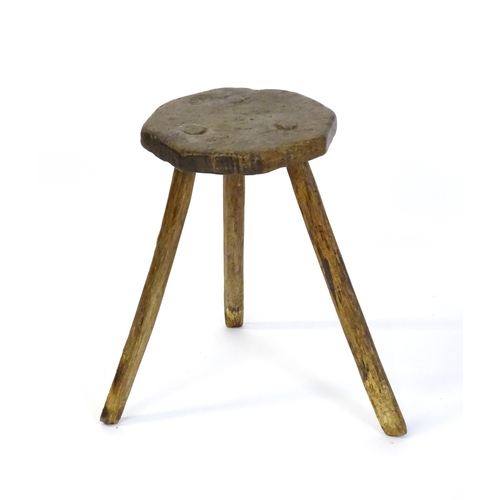 1500 - A 19thC primitive stool of large proportions, the octagonal top raised on three legs. 24