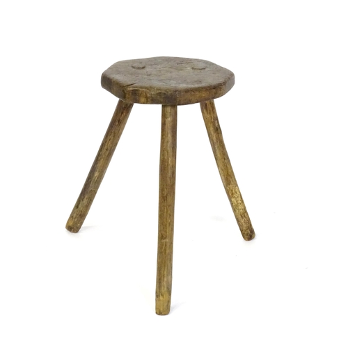 1500 - A 19thC primitive stool of large proportions, the octagonal top raised on three legs. 24