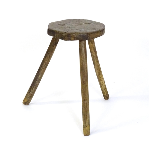 1500 - A 19thC primitive stool of large proportions, the octagonal top raised on three legs. 24