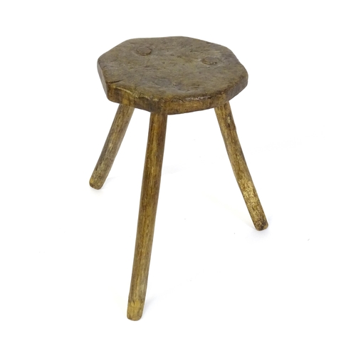 1500 - A 19thC primitive stool of large proportions, the octagonal top raised on three legs. 24