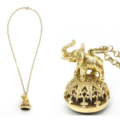 770 - A 9ct gold pendant fob seal surmounted by an elephant and set with facet cut smoky quartz under, on ... 