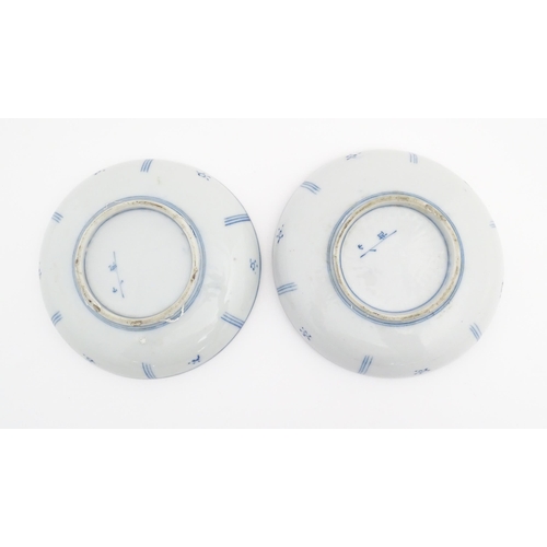 75 - A pair of Oriental blue and white dishes each depicting a figure on a bridge looking out to sea with... 