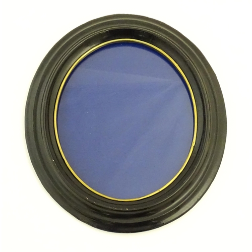 90 - A pair of early 20thC ebonised frames of oval form. Together with a ebonised frame of circular form.... 