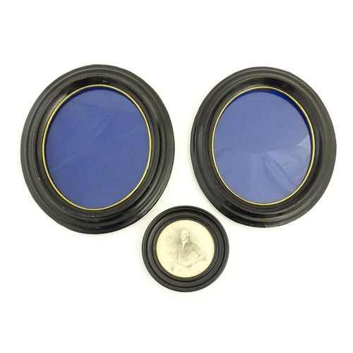 90 - A pair of early 20thC ebonised frames of oval form. Together with a ebonised frame of circular form.... 