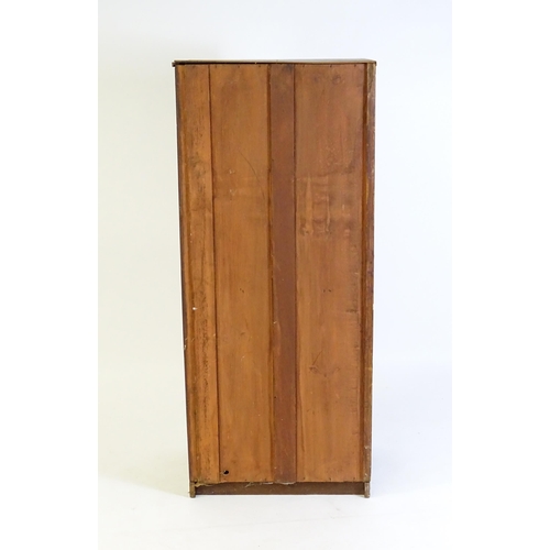 125 - A late 19thC / early 20thC mahogany cabinet with a panelled door above three short drawers with turn... 