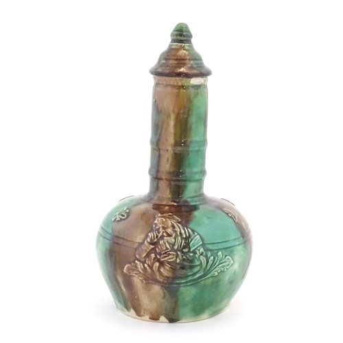 177 - A majolica bottle vase and cover with relief decoration depicting the snuff taker. Approx. 10