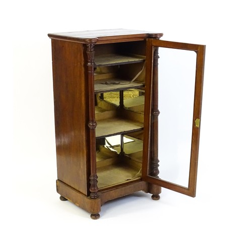 215 - A late 19thC / early 20thC music cabinet of larger proportions, having a castellated front edge, two... 