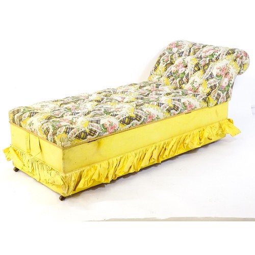 224 - An early / mid 20thC chaise longue with deep buttoned floral upholstery and raised on four castors. ... 