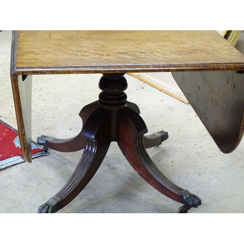 247 - A Regency drop flap mahogany table, with drop flaps to either side, a turned pedestal and four reede... 