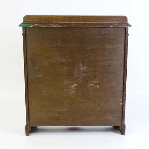 266 - A mid 20thC oak glazed bookcase with a shaped upstand above carved detailing with beadwork mouldings... 