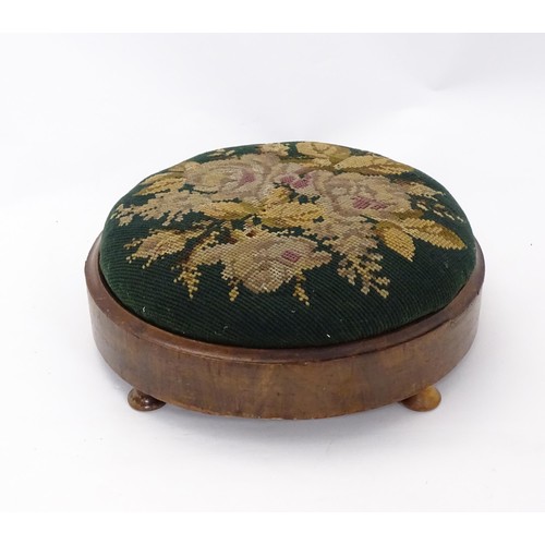 273 - A 19thC circular needlework footstool with an inset upholstered seat and a walnut frame raised on sq... 