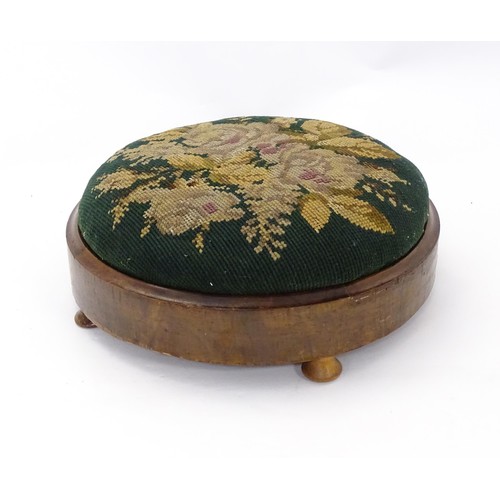 273 - A 19thC circular needlework footstool with an inset upholstered seat and a walnut frame raised on sq... 